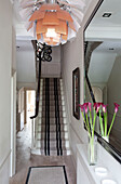 Floral ceiling lampshade in hallway of contemporary London home with carpeted staircase, UK