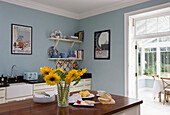 Cut sunflowers in light blue kitchen of Tyne & Wear home, England, UK