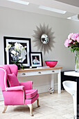 Pink upholstered armchair in contemporary London home, UK