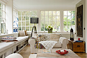 Unverkleideter Wintergarten mit cremefarbenem Sofa in einem Haus in Surrey, Großbritannien