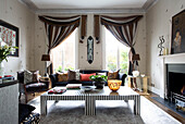 Braun gestreifte Vorhänge mit passenden Couchtischen im Wohnzimmer eines modernen Londoner Stadthauses, England, UK