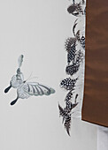 Butterfly wall decor and feathers in contemporary London townhouse, England, UK