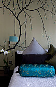 Oriental style wall decor and bed with cushions, detail in contemporary London townhouse, England, UK