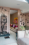 Birdcage and wall decor in pink living room in contemporary London townhouse, England, UK