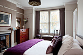 Polished wooden chest of drawers in bedroom with purple woollen blanket, contemporary home, Hove, East Sussex, England, UK