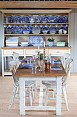 Esstisch für vier Personen mit blauem und weißem Porzellan in einer Küchenkommode in einem Bauernhaus in Kent, England UK