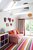 Gestreifter Teppich und kariertes Sofa im Spielzimmer eines Familienhauses in Herefordshire England UK