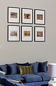 Kunstwerke über einem blauen Sofa in einem klassischen Londoner Haus, UK
