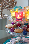 Lit candles and mince pies on cake stand in London home, UK