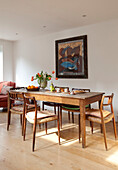 Vintage dining table and chairs with artwork in London home, UK