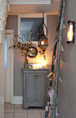 Lit candles with Christmas cards on ladder display in hallway of London home, England, UK