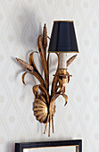 Rustic gold metallic wall sconce in Sussex farmhouse, England, UK