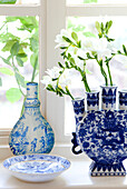 Single stem flowers in blue and and white chinaware on Sussex farmhouse windowsill, England, UK
