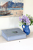 Cut flowers and a light blue writing box with artwork in coastal Sussex cottage, England, UK