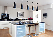 Modern black pendant lights in contemporary kitchen, Berkshire warehouse conversion, England, UK