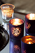 Lit tealights in purple candle holders in Surrey farmhouse, England, UK