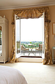 View through open doors to balcony exterior of Sussex country house, England, UK