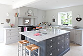 Marble topped kitchen island in contemporary kitchen of Maidstone farmhouse, Kent, England, UK