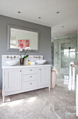 Double wash basin on grey partition wall in bathroom of Maidstone farmhouse, Kent, England, UK
