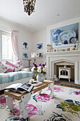 Cut flowers and books on coffee table in living room with assorted fabrics in Dulwich home London England UK