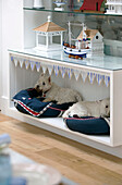 Built-in dog beds with white terriers underneath shelves with nautical objects in Dulwich home London England UK