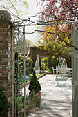 View through gateway to paved terrace of historic Sussex country home England UK