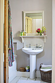 Sockelwaschbecken und quadratischer Spiegel im Badezimmer eines Cottage in Dorset, England, Vereinigtes Königreich