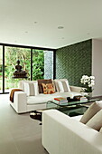 Buddha statues with white sofas in living room of contemporary new build, Kingston upon Thames, England, UK