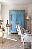 Blue painted wardrobe in terracotta tiled living room of Mougins apartment, Alpes-Maritime, South of France
