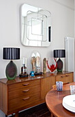Vintage wooden sideboard and table with square mirror in London townhouse, England, UK