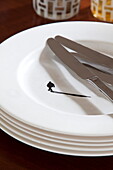 Knives and plates with shadow figure in London townhouse, England, UK