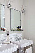 Double basins with vintage lighting and mirrors in bathroom of London townhouse, England, UK