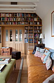 Tan leather sofa and bookcase in living room of Kent home, England, UK