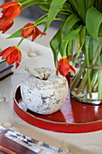 Vase mit Tulpen und Apfelschmuck mit rotem Tablett in einem Bauernhaus in Staffordshire England UK