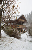 Wooden mountain chalet on snowy hillside, Chateau-d'Oex, Vaud, Switzerland