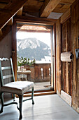 Gepolsterter Stuhl am Eingang mit Blick auf die Berge in einem Chalet in Chateau-d'Oex, Waadt, Schweiz