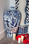 Blue and white Chinese urn with lit candles and gift-wrapped presents in Chilterns home England UK