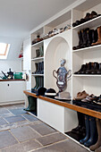 Wellington boots and riding hats on shelving in Chilterns home, England, UK