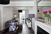 Lilac standard lamp with brown seating in double living room of contemporary Brighton home, East Sussex, England, UK