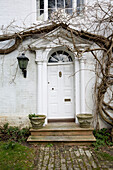 White front door with pot plants, Burwash home, East Sussex, England, UK