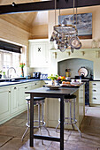 Pan rack above breakfast bar in flagstone kitchen of Burwash home, East Sussex, England, UK