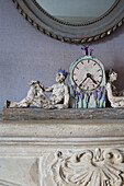 Figurines and clock on stone mantlepiece in Burwash home East Sussex England UK