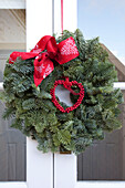 Red ribbon on Christmas wreath at exterior of West Sussex home, England, UK