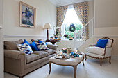 Hellblaue Kissen auf Sessel und Sofa im Wohnzimmer eines Hauses in West Sussex, England UK