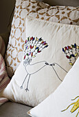Embroidered birds on cushion in London home England UK