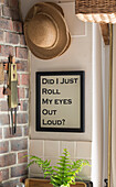Sunhats and framed poster in farmhouse kitchen, UK