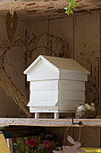 Scale model of beehive with birds nest and eggs on shelf in UK farmhouse