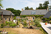 Kitchen garden with decking area at exterior of French farmhouse cottage
