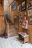 Black and white photographs and vintage scooter in wooden stairway of French farmhouse cottage