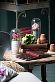 Hardbacked books with roses in display cases on wooden table in French farmhouse cottage